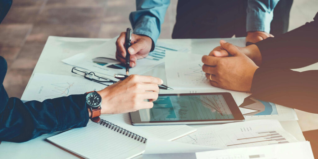 reunión de trabajo con tablet y gráficos para toma de decisiones